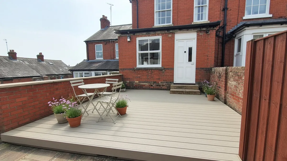 Example image: pale sand-coloured composite deck in the back yard of a Victorian brick terrace near the sea